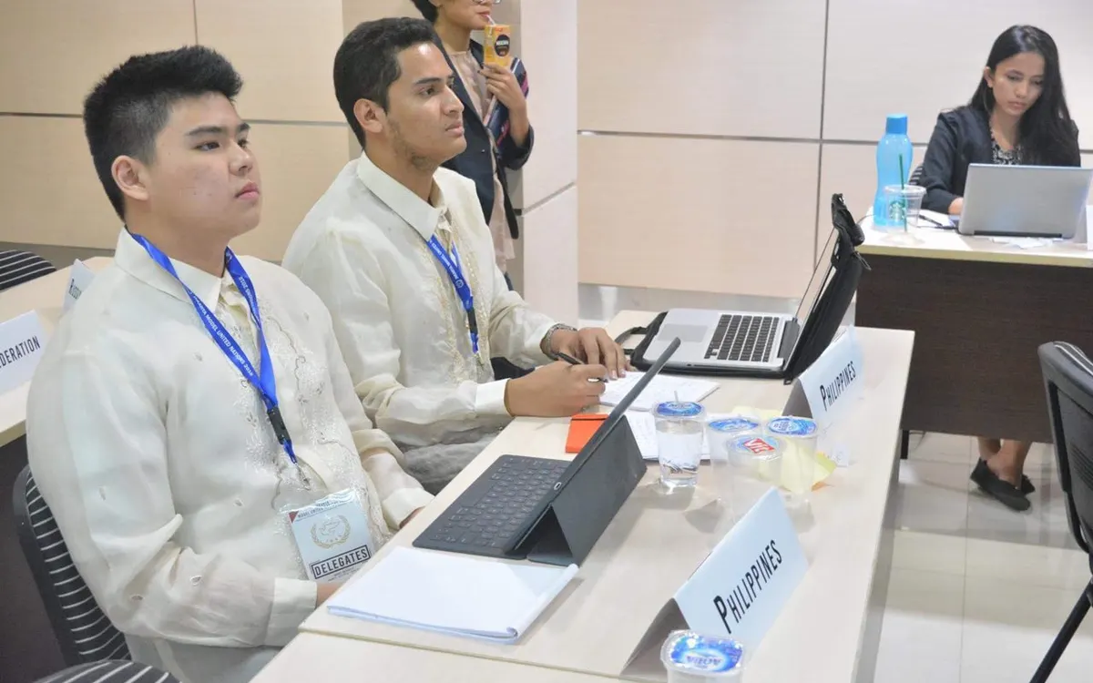 Two delegates in the Security Council at Jakarta Model United Nations, seated at a table with a laptop and a Philippines placard