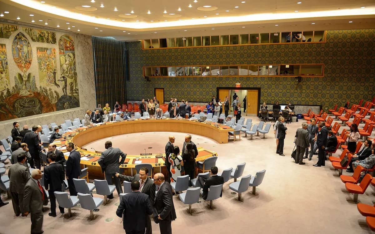 Diplomats standing and talking in the UN Security Council chamber before a meeting begins